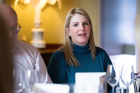 Photograph of RGI Solutions director Sarah Glenn mid-conversation at the roundtable. She wears a teal turtle-neck jumper.